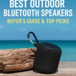 A black rugged outdoor Bluetooth speaker with a carabiner sits on a wooden surface beside a weathered log, with a bright blue ocean and clear sky in the background. Bold white and yellow text reads “Best Outdoor Bluetooth Speakers – Buyer’s Guide & Top Picks.